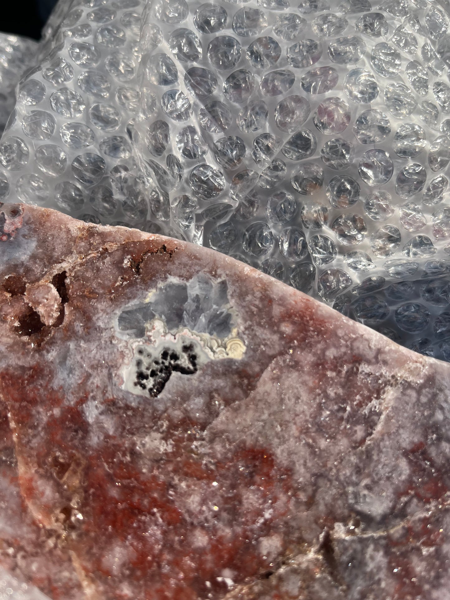 Stunning polished slice with pink amethyst, clear quartz and agate on stand.