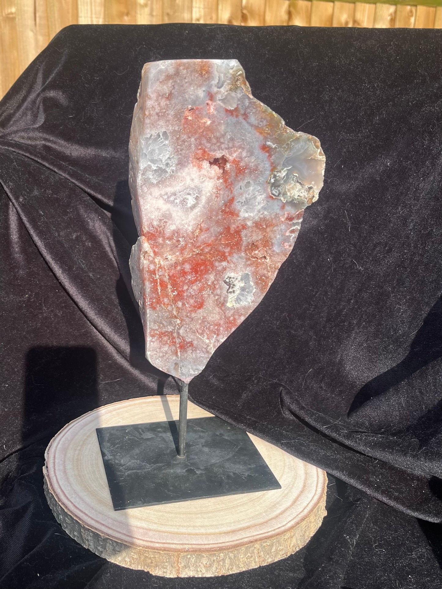 Stunning polished slice with pink amethyst, clear quartz and agate on stand.
