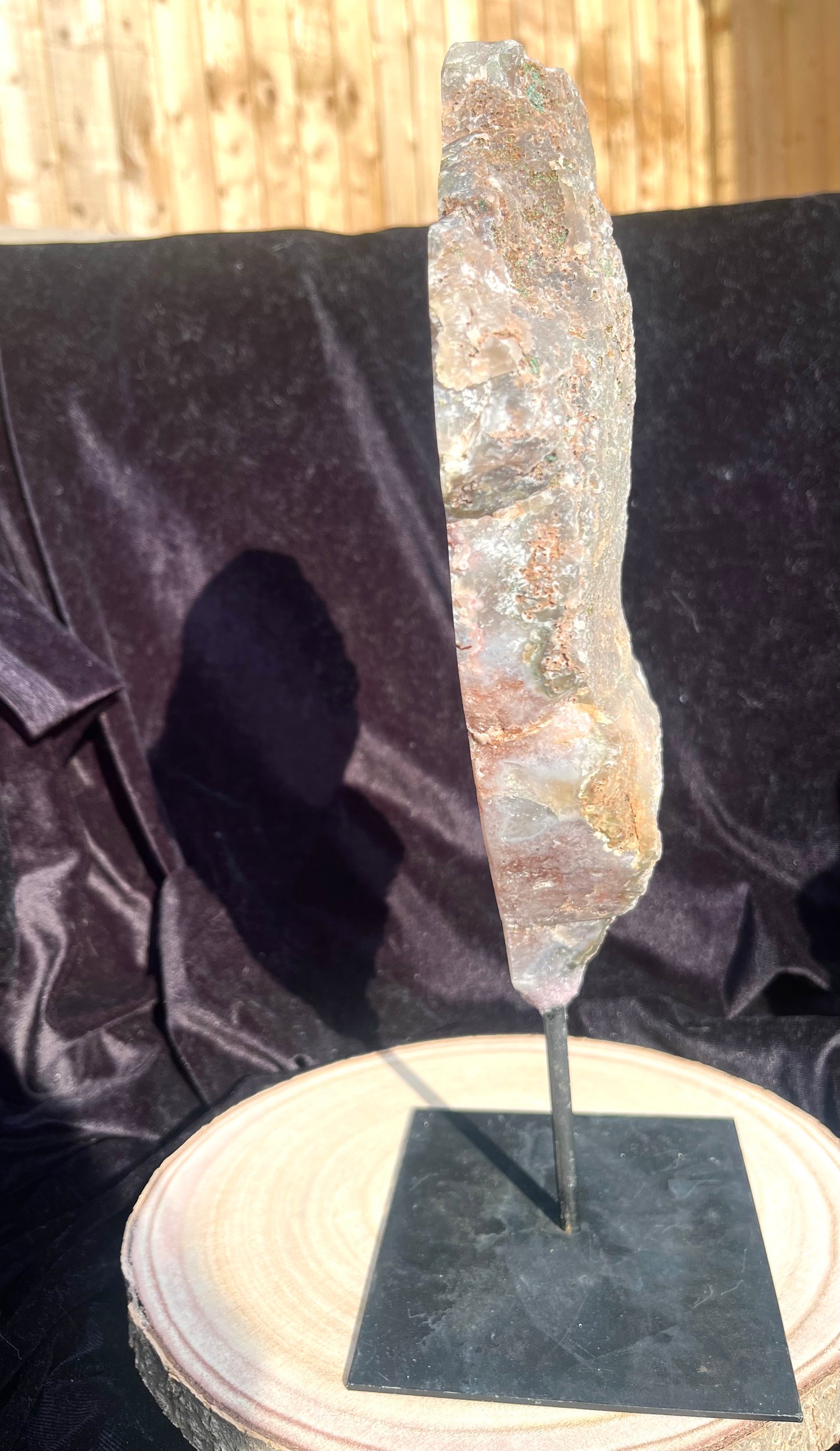 Stunning polished slice with pink amethyst, clear quartz and agate on stand.