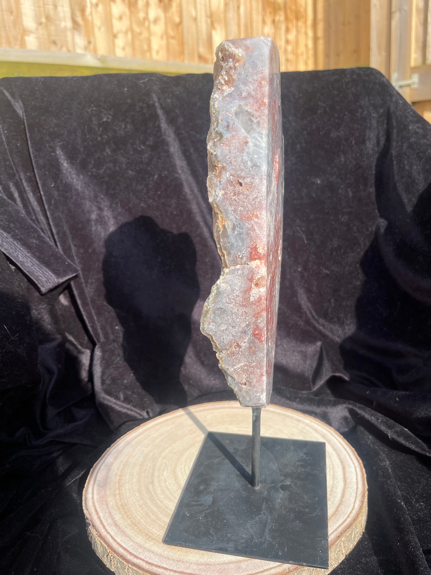 Stunning polished slice with pink amethyst, clear quartz and agate on stand.