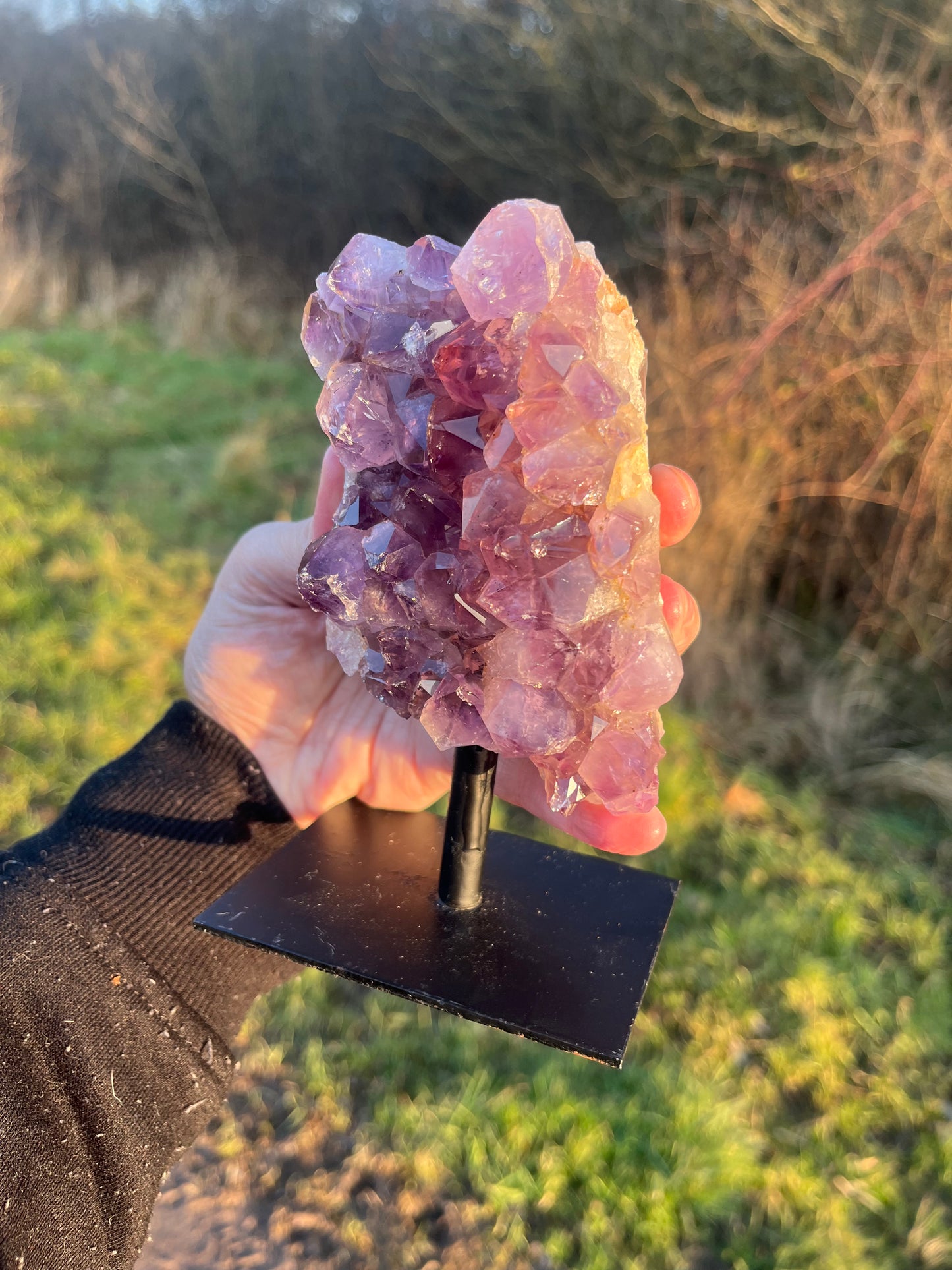 A grade Amethyst cluster on stand (attached). 730g.
